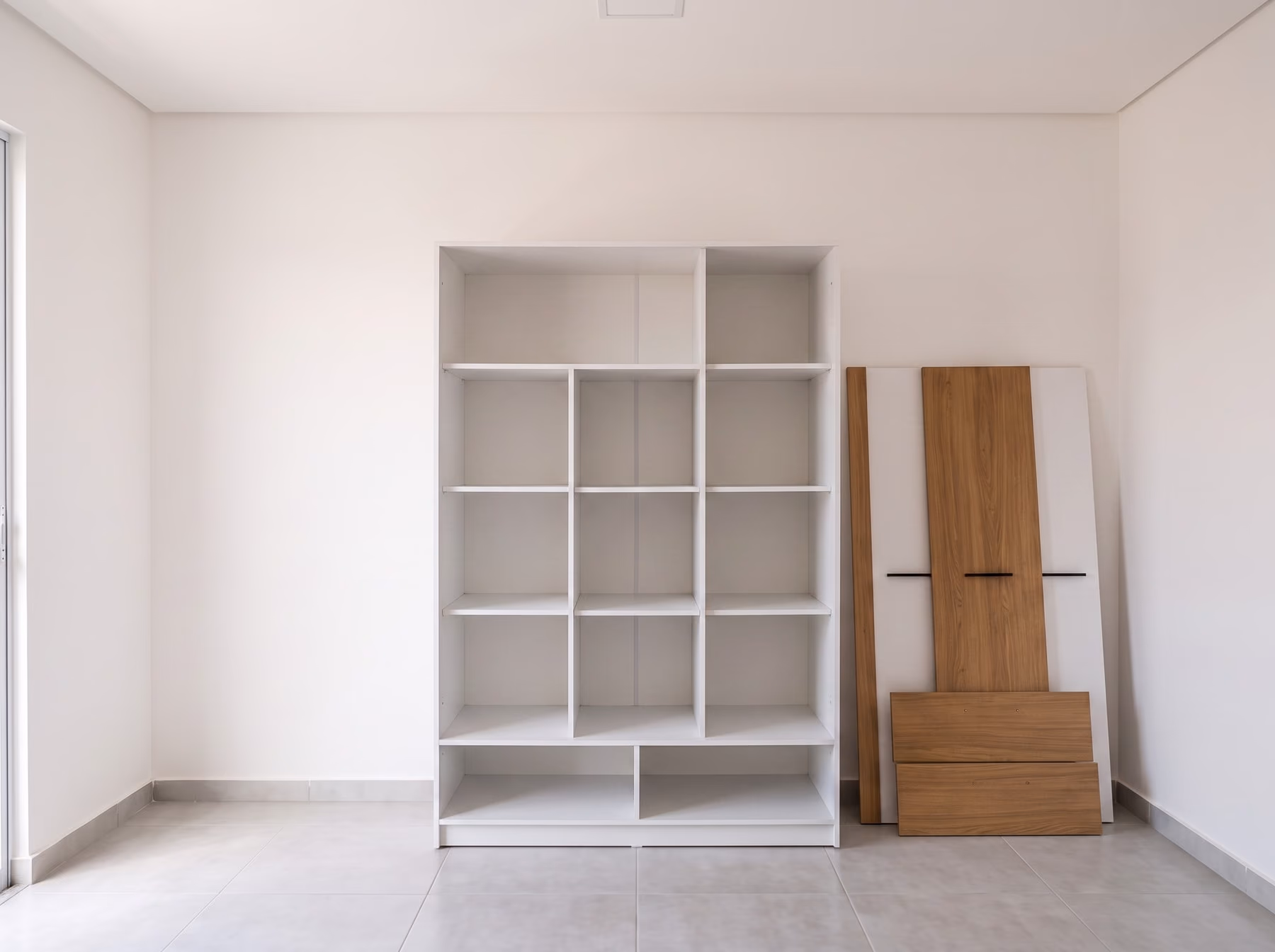 Estrutura do guarda-roupa já montada, com as portas encostadas na parede aguardando instalação