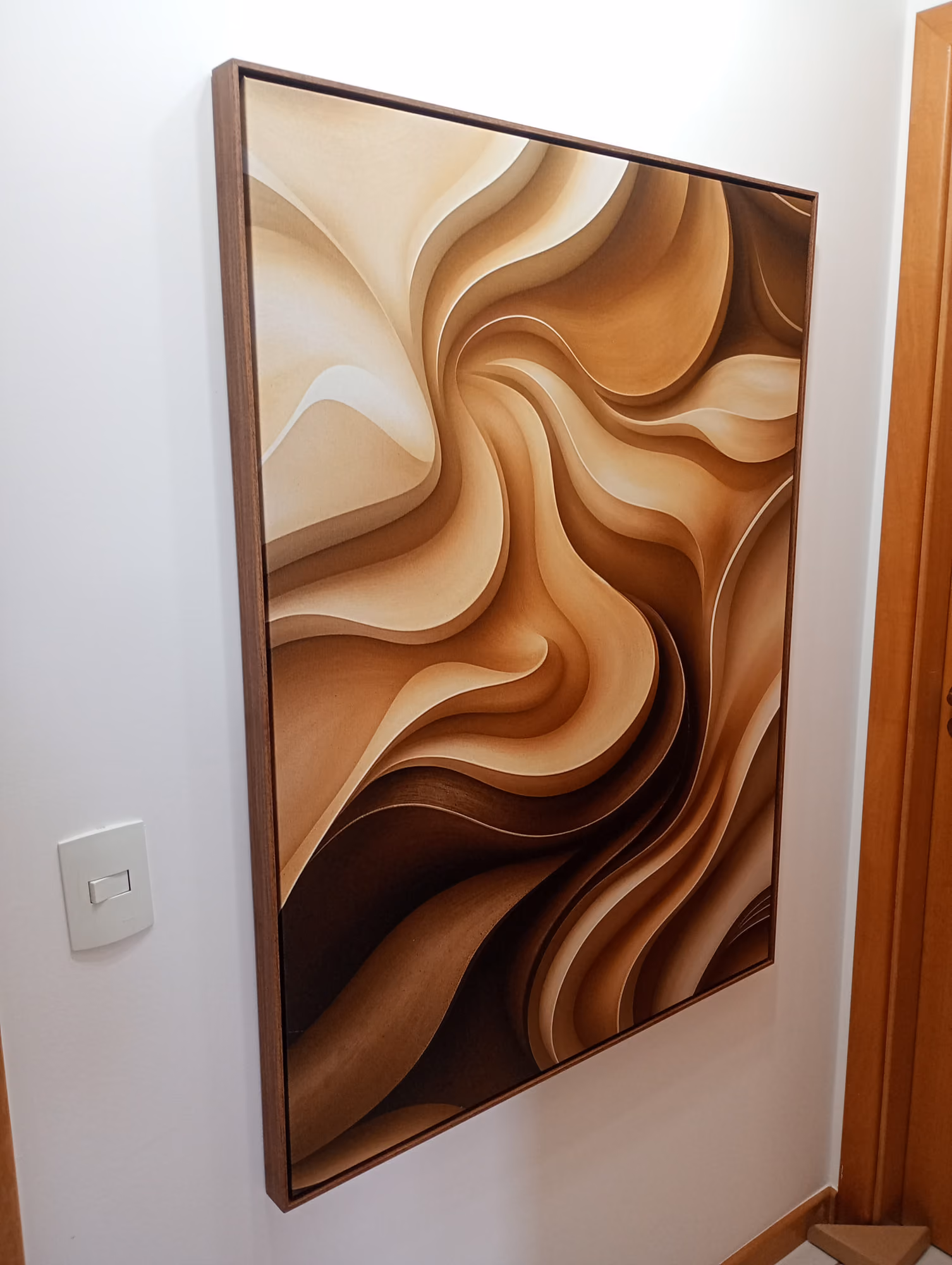 Quadro grande com moldura de madeira instalado em parede de corredor residencial