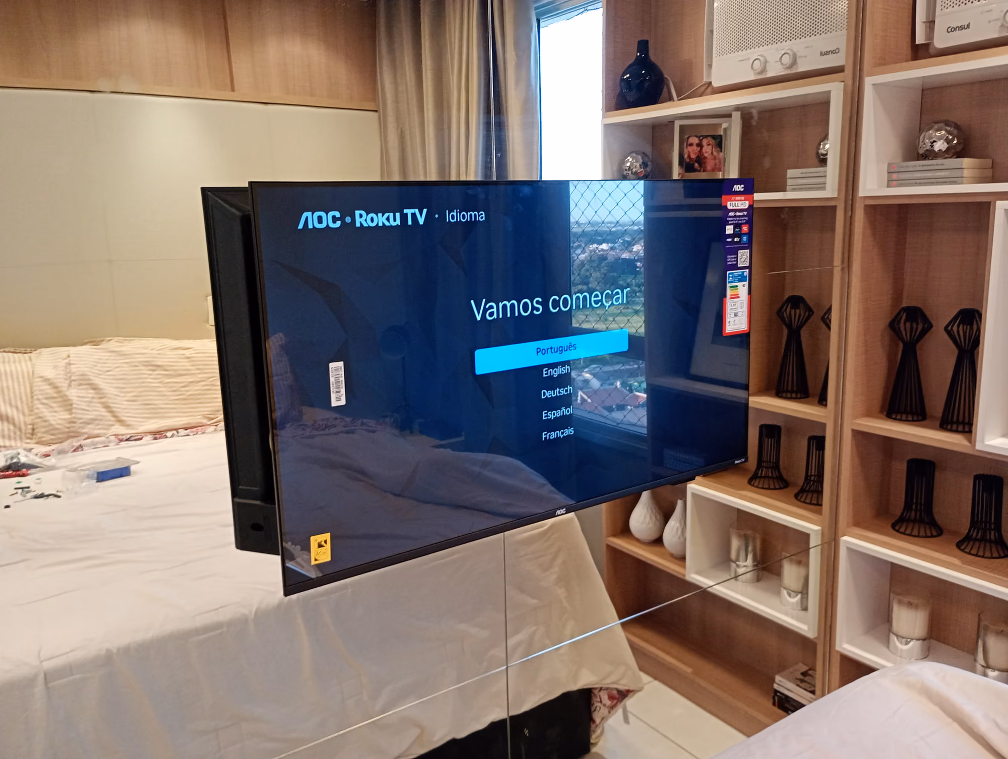 Smart TV AOC instalada em suporte de parede em quarto de apartamento