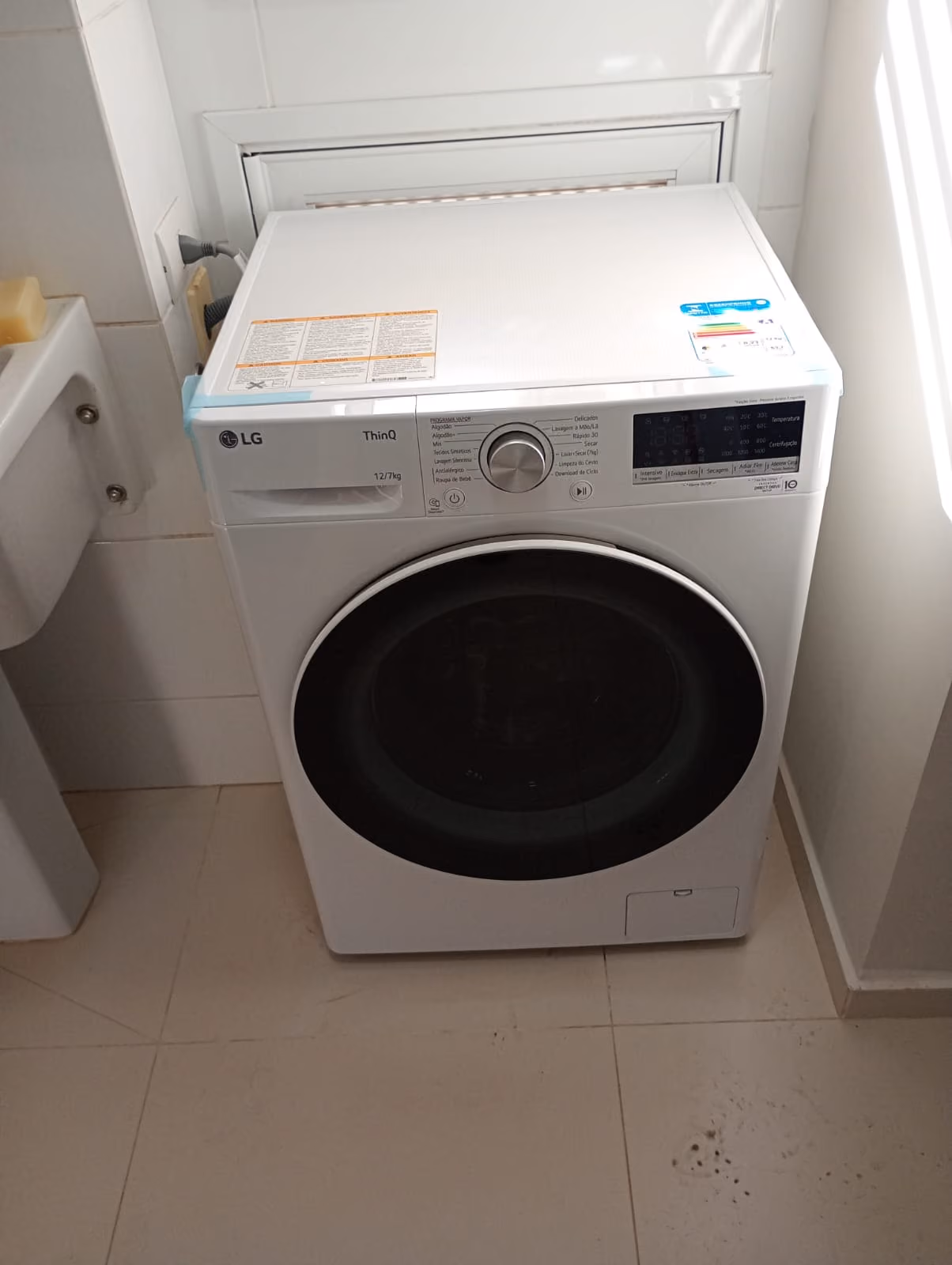 Lava e seca LG instalada e nivelada em área de serviço de apartamento
