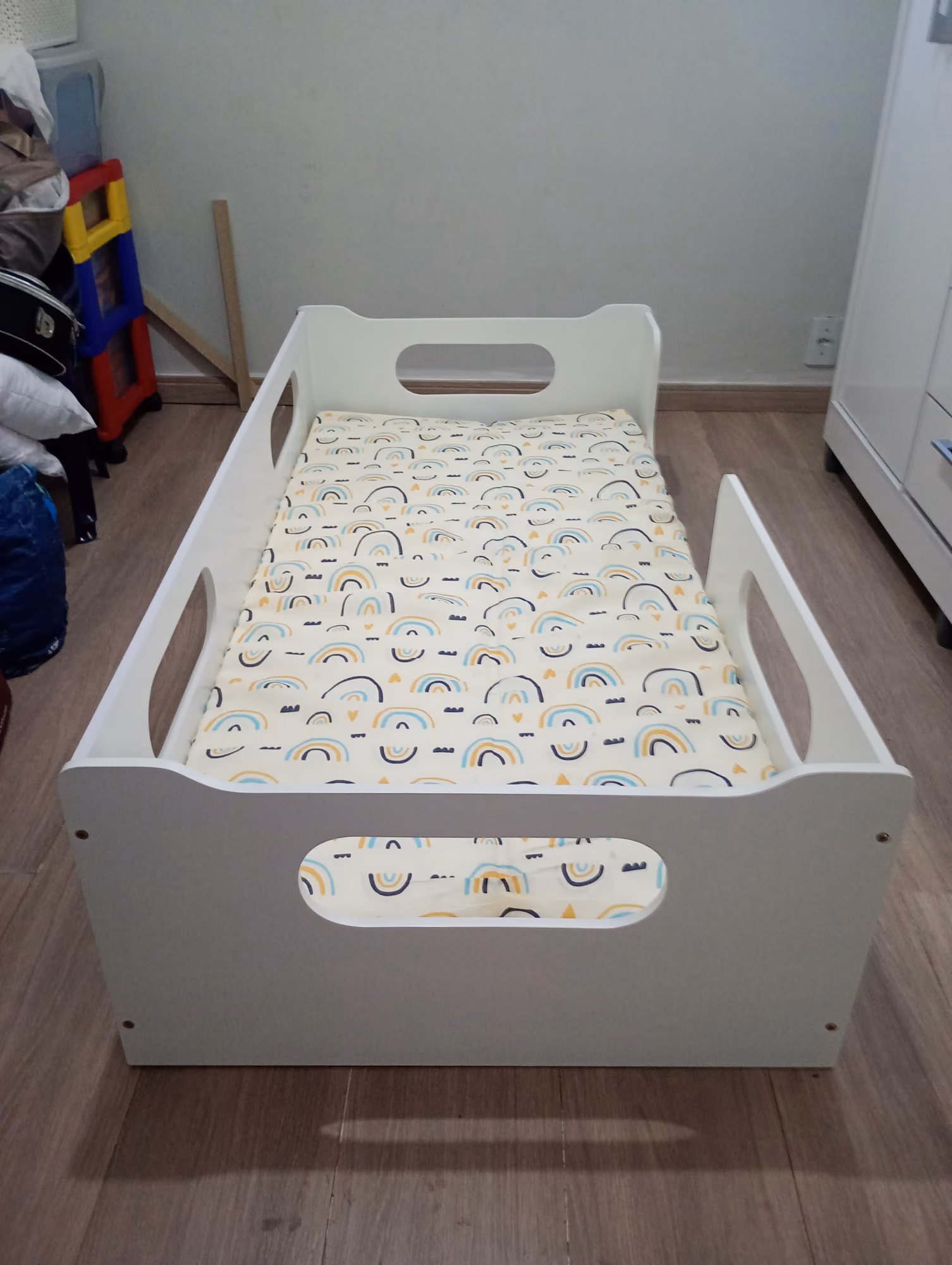 Cama infantil branca com grades de proteção montada em quarto de criança