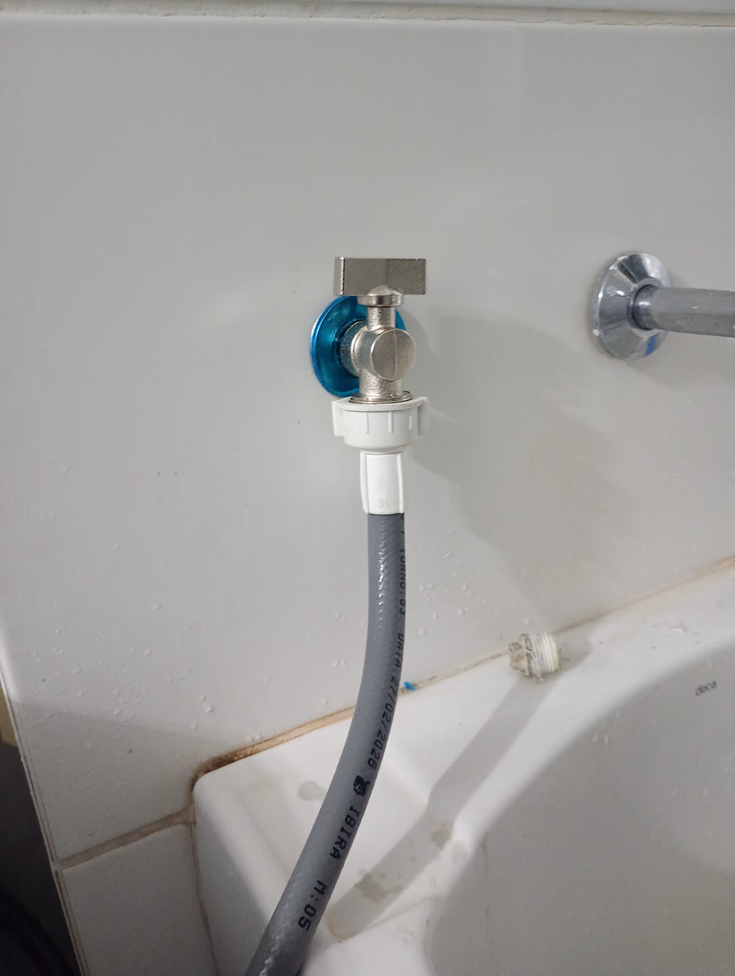 Registro e mangueira de entrada de água instalados para máquina de lavar na área de serviço