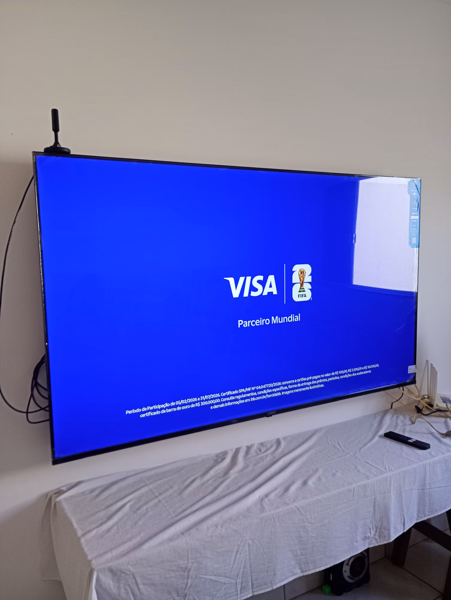 Smart TV grande fixada em suporte de parede em sala de apartamento em Campo Grande - MS