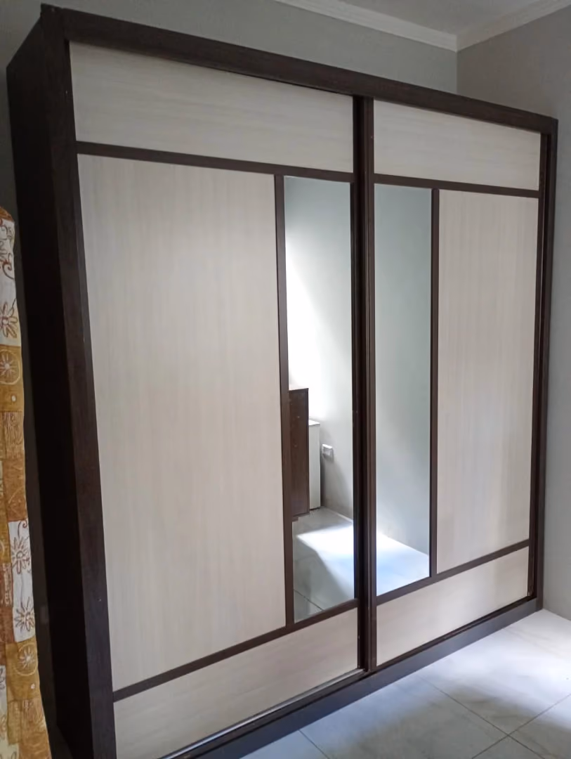 Guarda-roupa de portas de correr com espelho instalado em quarto de apartamento